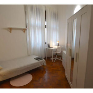 vista generale della stanza singola composta da letto singolo, armadio con specchio, zona studio e finestra