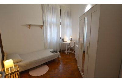 vista generale della stanza singola composta da letto singolo, armadio con specchio, zona studio e finestra