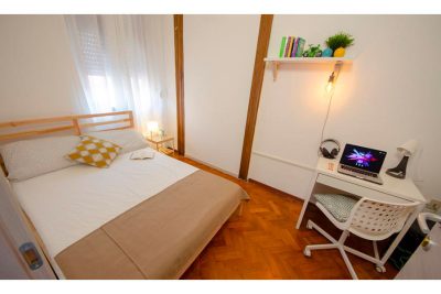 vista generale della stanza con letto matrimoniale e scrivania