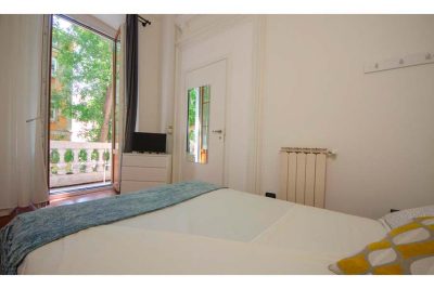 vista della stanza dal letto matrimoniale che punta sul balcone privato