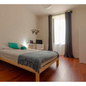 vista della suite con letto matrimoniale, comodino, armadio, scrivania con sedia e finestra