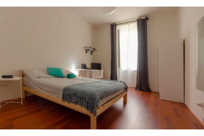 vista della suite con letto matrimoniale, comodino, armadio, scrivania con sedia e finestra