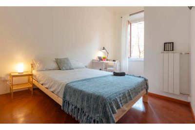 vista della stanza con letto matrimoniale arredato con un copriletto blu