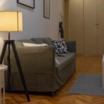 divano grigio da tre posti con luce da terra