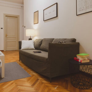 divano grigio da tre posti con tavolino e libri