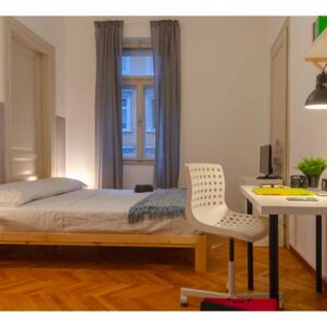 panoramica della stanza, con letto matrimoniale, tavolo e scrivania, lampada e comodini