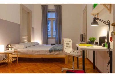 panoramica della stanza, con letto matrimoniale, tavolo e scrivania, lampada e comodini