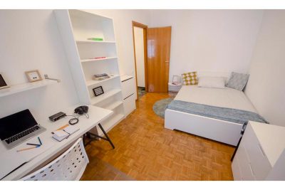 vista generale della stanza arredata con letto matrimoniale, libreria e zona studio lavoro