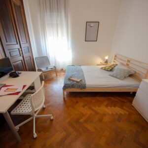 vista generale della stanza con letto matrimoniale, zona studio e cassettiera