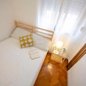 dettaglio del letto matrimoniale con comò e lampada