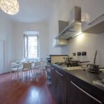 vista della zona pranzo, con cucina lineare e tavolo per sei persone