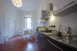 vista della zona pranzo, con cucina lineare e tavolo per sei persone