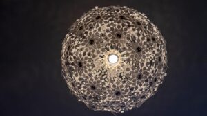 dettaglio della illuminazione: gioco di luci del lampadario con decori traforati