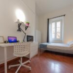 vista della stanza singola con sedia, scrivania, letto matrimoniale, cassettiera, tv e finestra