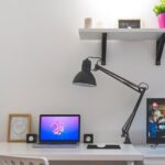 dettaglio della scrivania con lampada da tavolo e attrezzato per studiare con pc