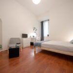 vista della stanza con letto matrimoniale, zona studio, finestra, cassettiera e tv