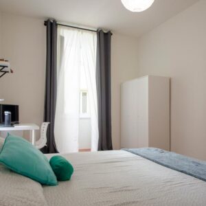 panoramica stanza con letto matrimoniale, armadio a tre ante scorrevoli e finestra