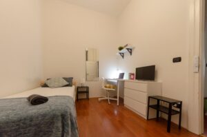 vista della stanza con letto singolo, armadio con specchio, zona studio, cassettiera e tv