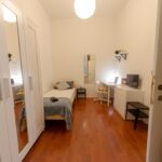 vista della stanza con letto singolo, armadio con specchio, zona studio, cassettiera e tv