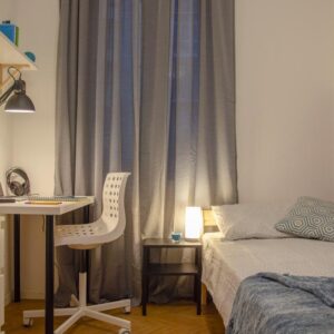 panoramica della stanza, con letto matrimoniale, tavolo e scrivania, lampada e comodini