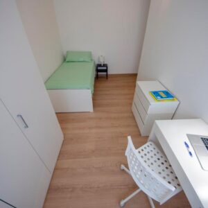 vista generale della stanza con scrivania, cassettiera, letto singolo e armadio