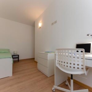 vista generale della stanza con letto singolo e zona studio lavoro