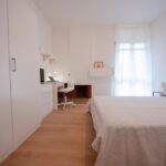 vista della stanza arredata con letto matrimoniale, armadio e scrivania con sedia