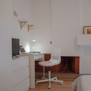 la zona studio lavoro è arredata con scrivania, mensola per libri, lampada da tavolo e sedia ergonomica