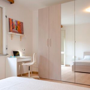 dettaglio sulla zona studio lavoro, armadio a quattro ante con specchio