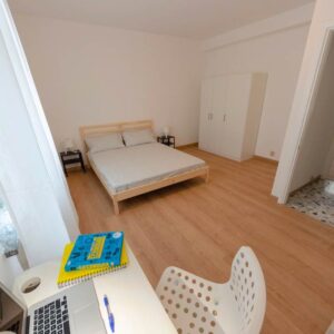 vista generale della stanza con letto matrimoniale, armadio, scrivania