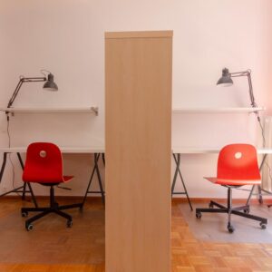 dettaglio delle zone studio con due postazioni composte di ripiano, scrivania, sedia ergonomica a rotelle e lampada da tavolo