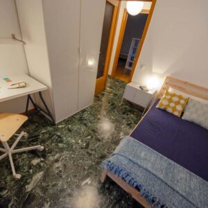 vista generale della stanza con letto matrimoniale e pavimento in terrazzo verdone