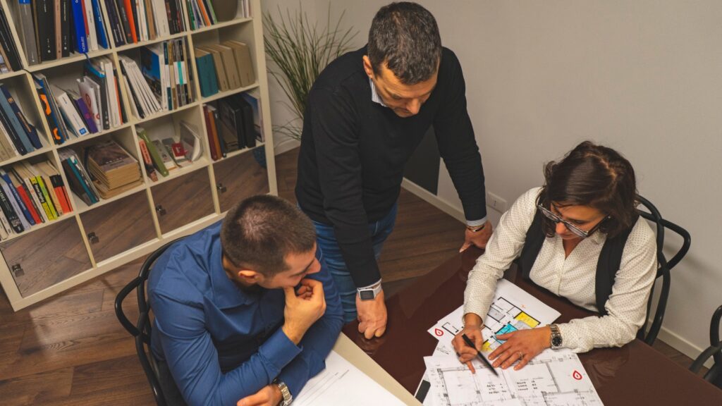 Team Ubiroom al lavoro –davanti ad un tavolo mentre analizzano una planimetria